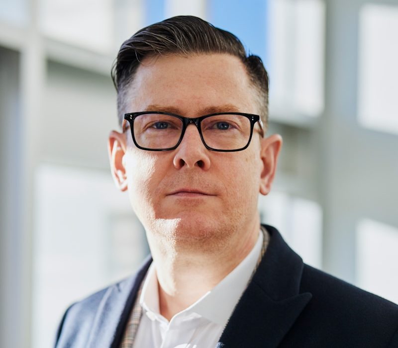 Photo by LinkedIn Sales Solutions man standing beside wall